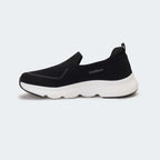 Caliber Shoes black knit slip-on sneakers with white EVA bubble sole and grey logo detail.