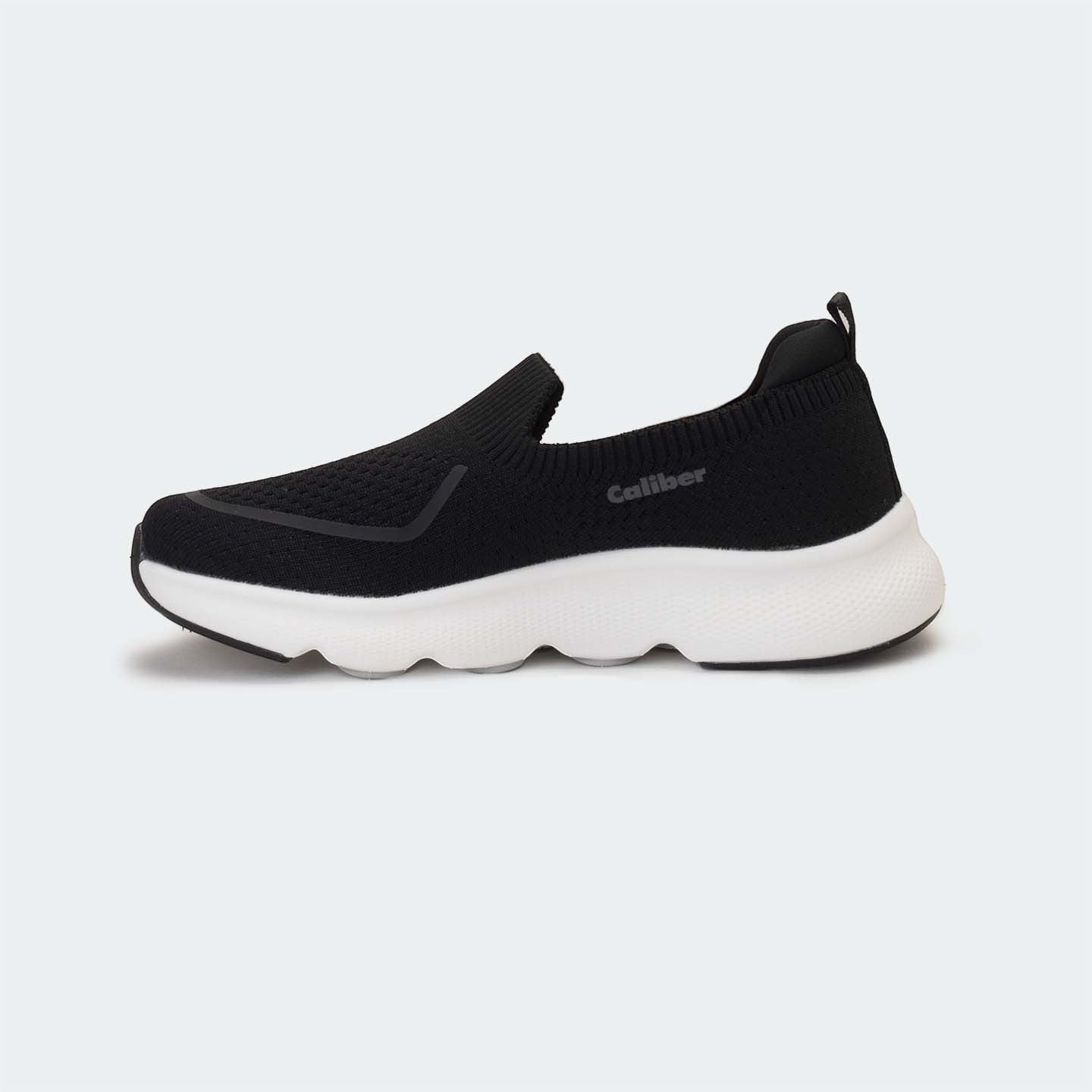 Caliber Shoes black knit slip-on sneakers with white EVA bubble sole and grey logo detail.