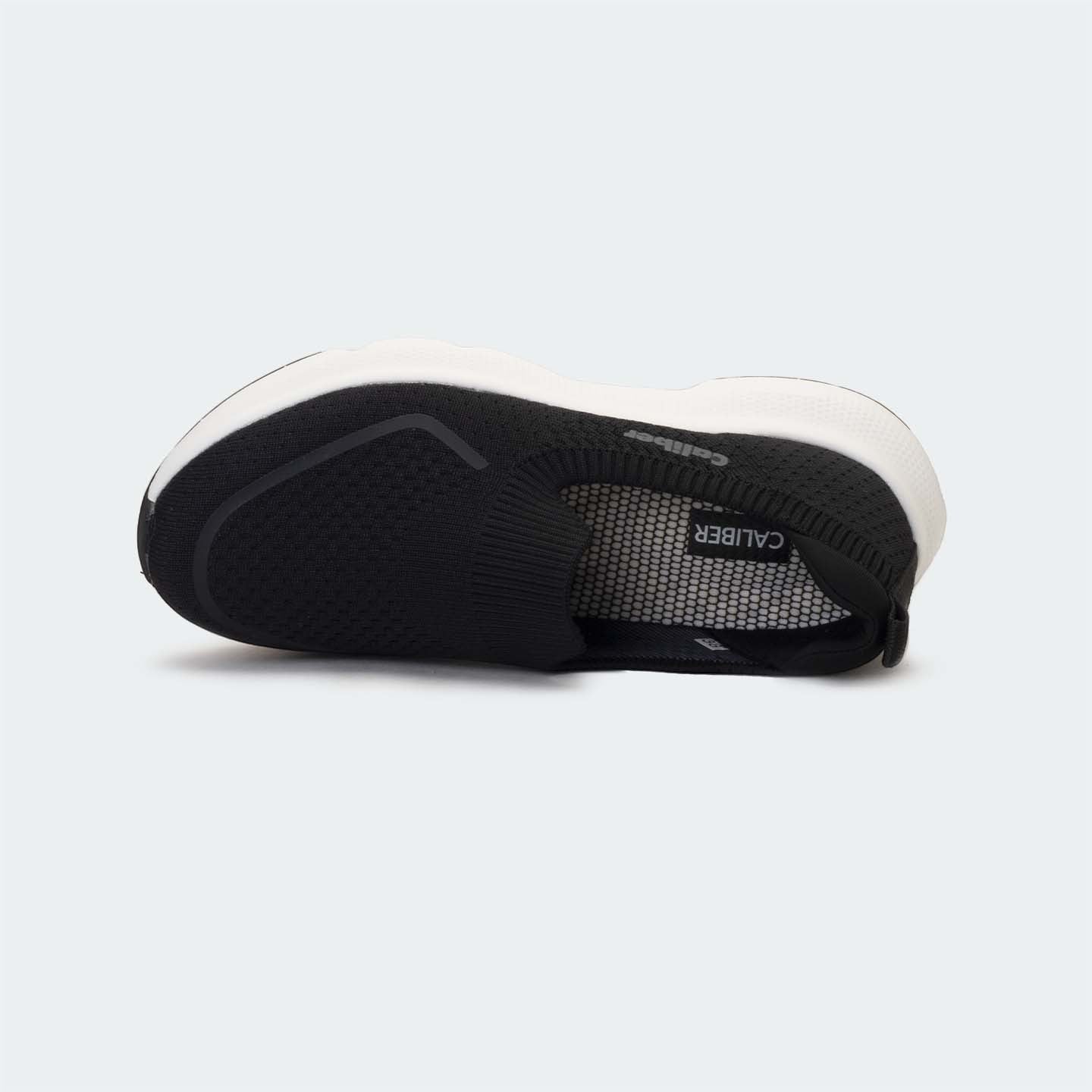 Caliber Shoes black knit slip-on sneakers with white EVA bubble sole and grey logo detail.