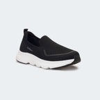 Caliber Shoes black knit slip-on sneakers with white EVA bubble sole and grey logo detail.