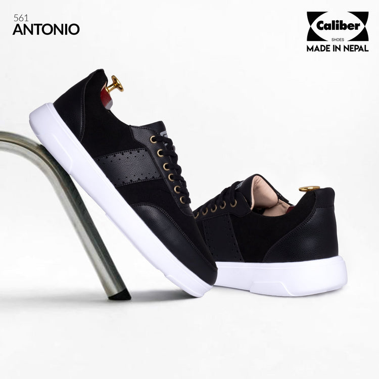 Black ANTONIO 561 casual sneakers for men, pair with perforated leather panels and white sole, resting on a metal stand